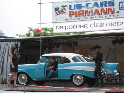 1992 Ford Crown Victoria - A blue and white 1957 Chevrolet Bel Air is displayed on a stage with people present.