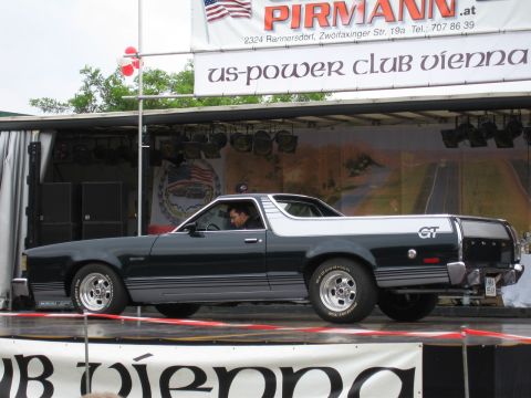 1992 Ford Crown Victoria - A Ford Ranchero GT pickup truck is shown from the side on a stage with a banner in the background.