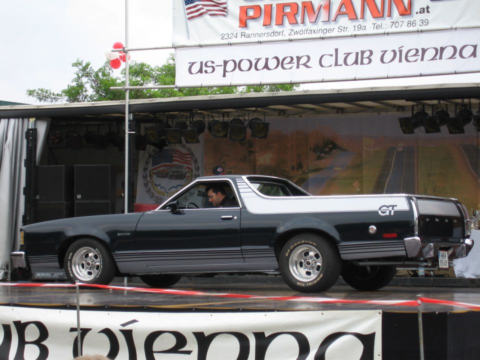 Black and silver Ford Ranchero GT pickup truck on display stage