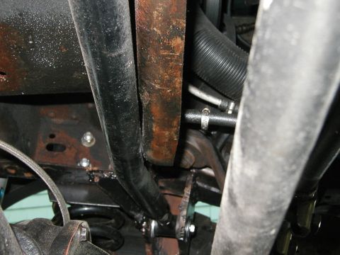 1994 Ford Bronco - Close-up of vehicle undercarriage, focusing on suspension and exhaust system parts.