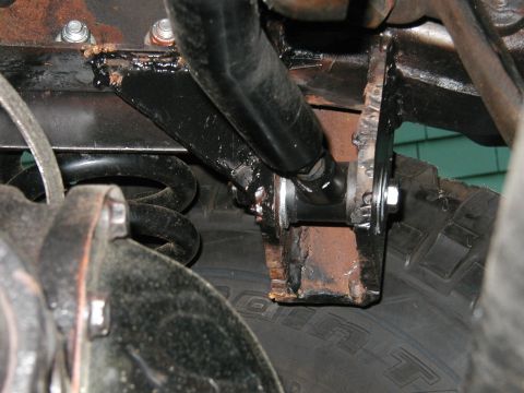 1994 Ford Bronco - Underside view of vehicle suspension components, showing rust and wear on metal parts.