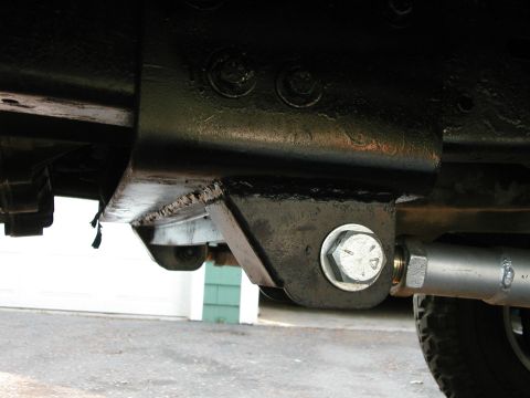 1994 Ford Bronco - Underside view of a vehicle's frame and suspension system, focusing on a bolted bracket and linkage.