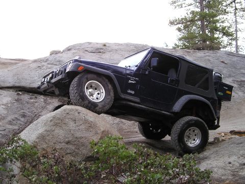 1989 Ford Bronco - Jeep Wrangler TJ navigating a rocky trail, demonstrating off-road capability.