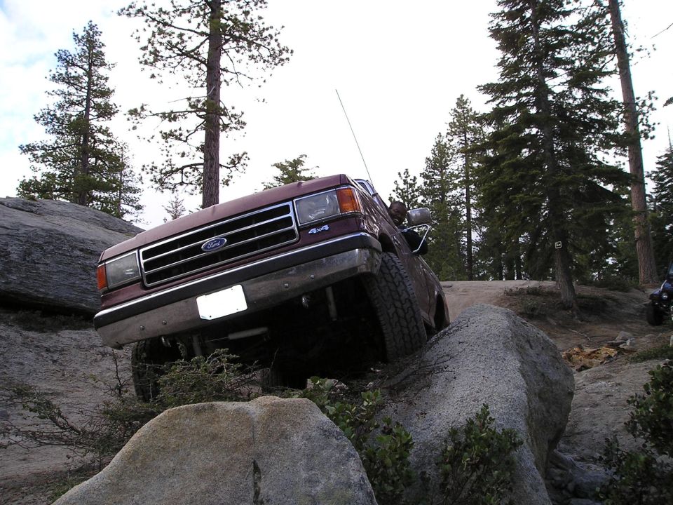 Maroon Ford Bronco navigating rocky terrain