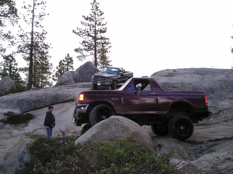 1989 Ford Bronco - Two trucks, a 1989 Ford Bronco and a Dodge Ram, navigate a challenging rocky trail.