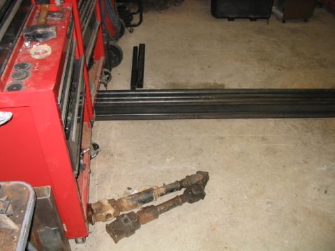 1986 Ford F-150 - Driveshafts and metal stock are visible in a garage setting next to a red toolbox.