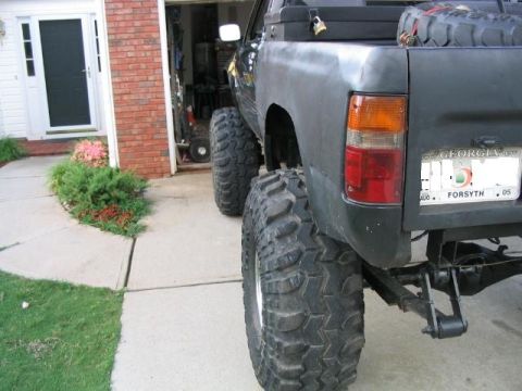 1986 Ford F-150 - This Toyota pickup truck has been modified with large off-road tires and a spare tire mounted in the bed.