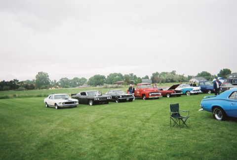 1972 Ford Ranchero - A collection of vintage vehicles are gathered on a lawn, with a red truck and various cars on display.