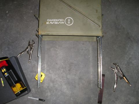 1996 Ford Bronco - An ammo can is being modified with metal legs and other tools are nearby.