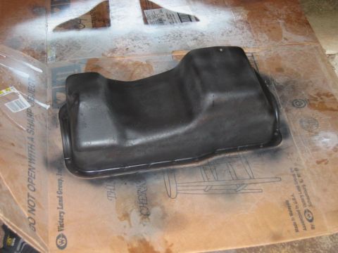 1985 Ford Crown Victoria LTD - Oil pan on cardboard, likely being prepped for painting or installation.