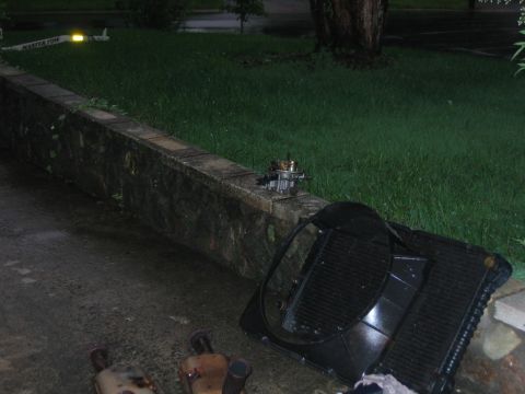 1985 Ford Crown Victoria LTD - Engine parts and a radiator are laid out on the ground next to a stone wall.