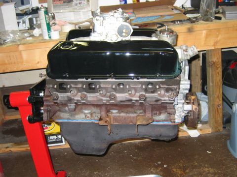 1985 Ford Crown Victoria LTD - A V8 engine is mounted on a red engine stand in a workshop setting.