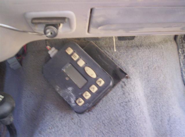 Aftermarket controller with buttons and a small screen on a carpeted floor