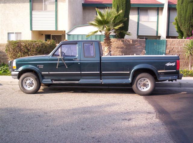 1995 Ford F-250 pickup truck, side view, dark green paint, crew cab