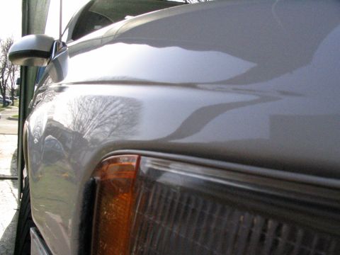 1993 Ford Taurus - A silver car's front fender and headlight are visible in this close-up shot.