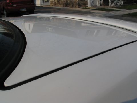 1993 Ford Taurus - A close-up view of a white car's roof, with another red vehicle visible in the background.