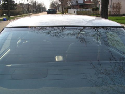 1993 Ford Taurus - View from inside a car looking out the rear window at a residential street scene.
