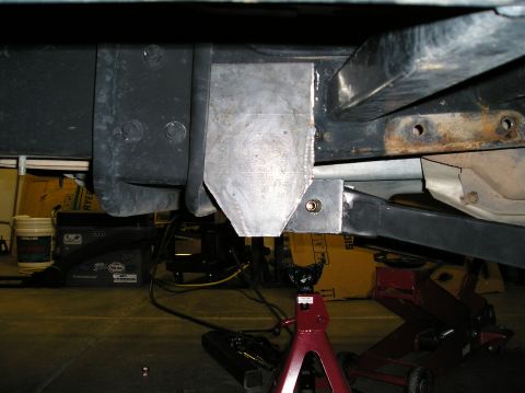 1993 Ford Bronco - Custom suspension bracket modification on a vehicle frame, supported by jack stands.