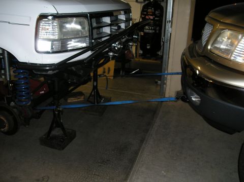 1993 Ford Bronco - The front end of a 1993 Ford Bronco is shown with custom suspension modifications, connected to a gold truck.