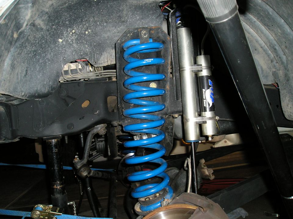 Blue Fabtech coil spring and Fox racing shock in a truck's front suspension