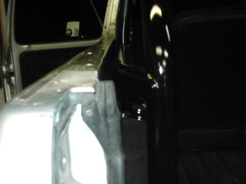 1978 Ford Bronco - Close-up view of the interior structure of a vehicle, including a roll cage and door frame.