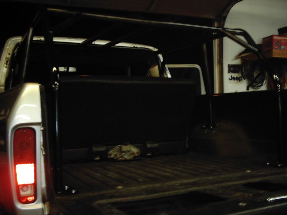 Rear view of a 1978 Ford Bronco with a roll cage and black interior