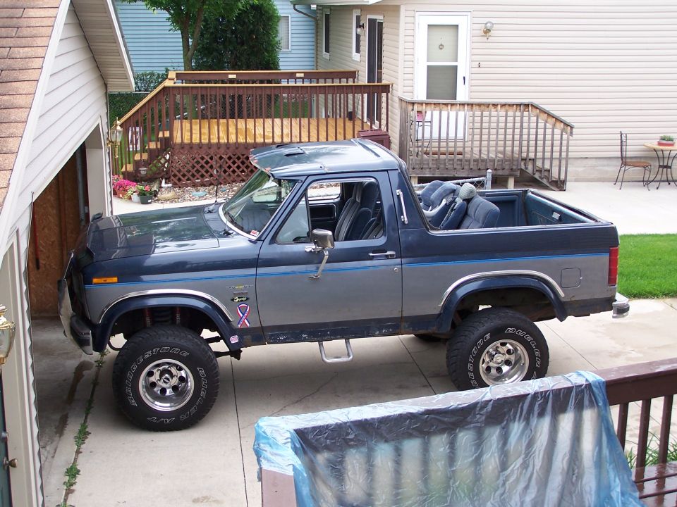 Blue and gray 1986 Ford Bronco with removable top, side view