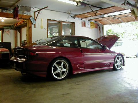 1994 Ford Probe - A red 1994 Ford Probe GT coupe is parked in a garage with its hood open.
