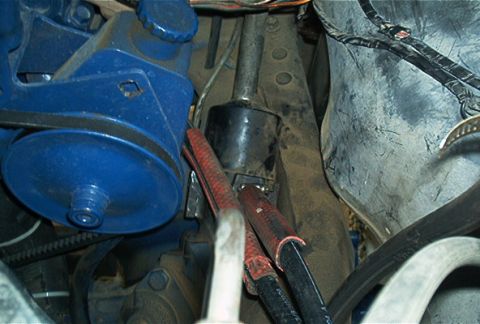 1986 Ford Bronco - This image shows various engine components, including a blue power steering pump and associated hoses.