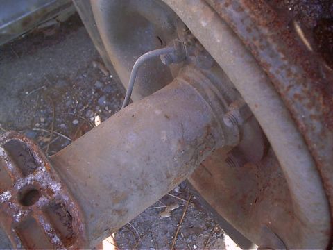 1979 Ford Bronco - Close-up view of a rusty axle and brake components, likely from an older vehicle.