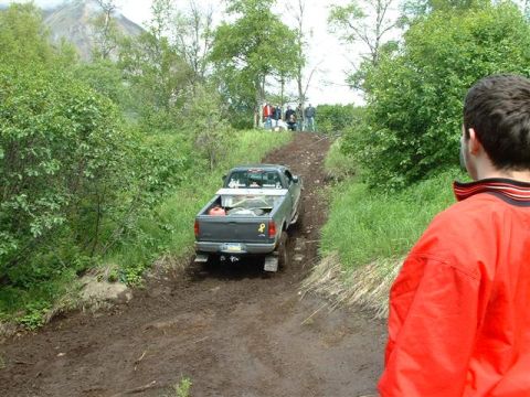 2000 Jeep Wrangler - Off-road adventure with a pickup truck navigating a challenging muddy trail.