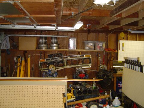 1989 Ford Bronco - Garage interior with car parts including a grille and engine block visible.