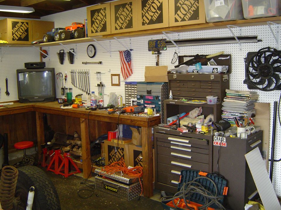 Garage workbench with tools, storage cabinets, and Home Depot boxes