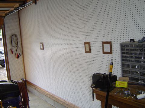 1989 Ford Bronco - Pegboard wall in a garage with a workbench and various tools and storage units.