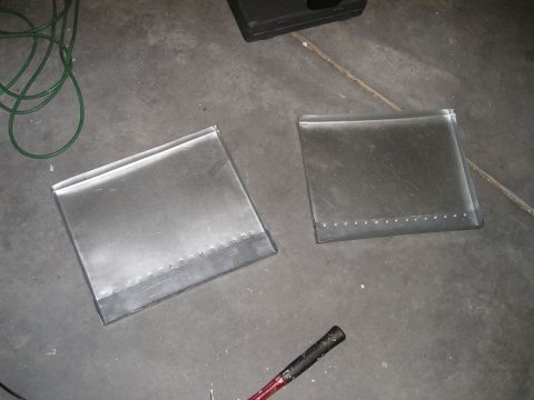 1996 Ford Bronco - Two unfinished metal containers sit on a garage floor next to a green cord and a tool handle.
