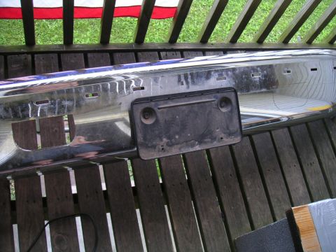 1994 Ford Bronco - A chrome bumper with a license plate bracket is shown, detached from a vehicle.