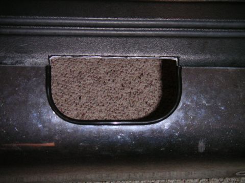 1994 Ford Bronco - A close-up view shows a rectangular cutout with rounded corners in a dark-colored vehicle panel.