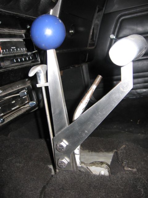 1972 Ford Mustang - Close-up of a custom shifter assembly with a blue knob and chrome handle, set against a dark car interior.