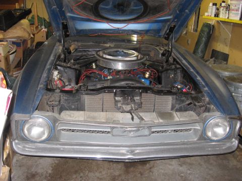 1972 Ford Mustang - The front of a blue 1971 Ford Mustang is visible with its hood open, revealing the engine bay.