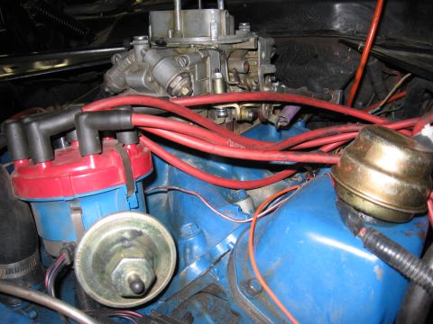 1972 Ford Mustang - The engine bay shows a carburetor and distributor with red spark plug wires.