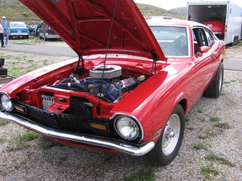1972 Ford Mustang - Red 1970 Ford Maverick coupe with its hood open, revealing the engine bay. A trailer is visible in the background.