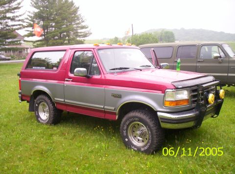 1995 Ford Bronco - This 1995 Ford Bronco is shown in a three-quarter front view, parked next to another vehicle.