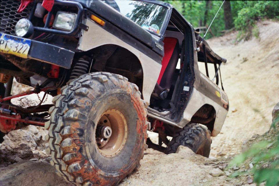 1978 Ford Bronco with large off-road tires on a dirt trail