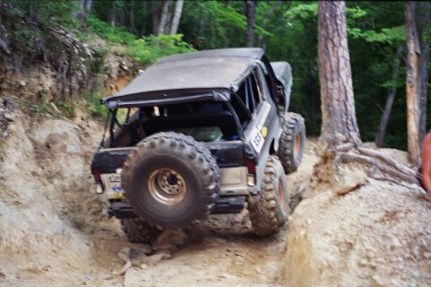 1978 Ford Bronco - A 1978 Ford Bronco navigates a challenging off-road trail with steep inclines and large rocks.
