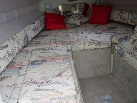 1997 Crownline 266 CCR - Interior view of a boat's seating area, patterned upholstery and red accent pillows.