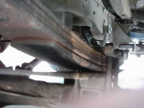 1978 Ford Bronco - Close-up of vehicle leaf springs and suspension parts, no year visible.