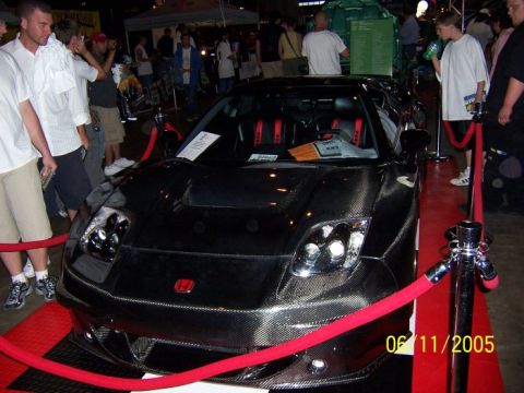 2005 Ford Focus - A black sports car, possibly a Honda NSX, is on display with red velvet ropes and stanchions.