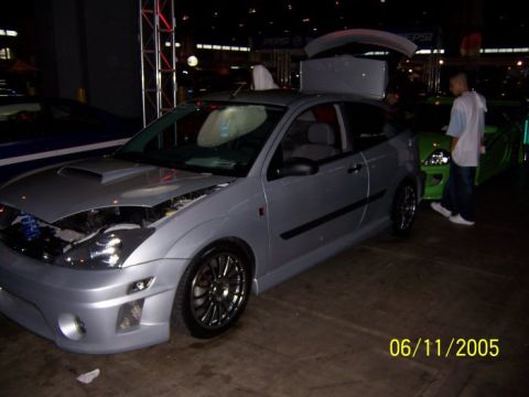 2005 Ford Focus - A silver 2005 Ford Focus hatchback is displayed with its hood open and rear spoiler raised, custom wheels.