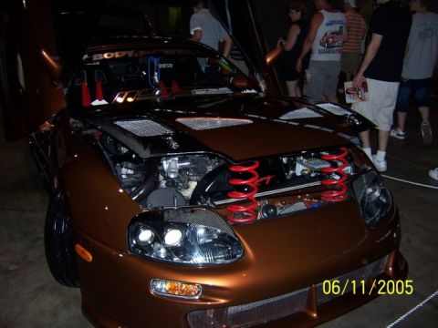 2005 Ford Focus - A customized copper sports car is displayed with its hood open, revealing the engine and suspension components.
