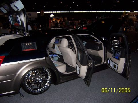 2005 Ford Focus - A customized sedan is displayed with its doors open, revealing interior screens and large aftermarket rims. The photo is dated 06/11/2005.